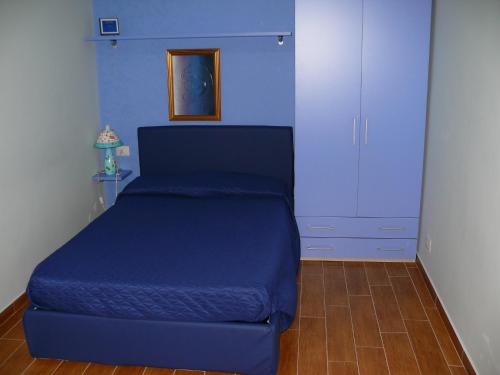 a blue bed in a room with a blue wall at B&B Max in Messina