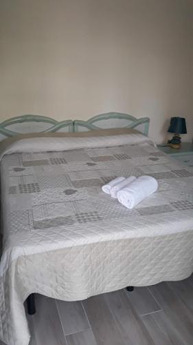 uma cama com duas toalhas em cima em B&b Il Giardinetto em Selargius