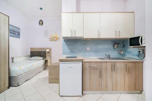 eine Küche mit einem Waschbecken und ein Bett in einem Zimmer in der Unterkunft Endless Blue Sea Resort in Skala Potamias