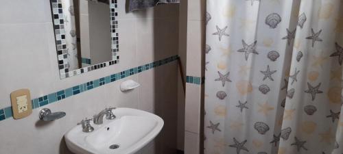 a bathroom with a sink and a shower curtain at Río de Chocolate in Santa María