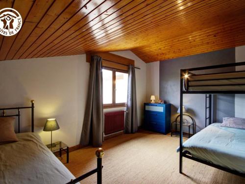 ein Schlafzimmer mit einem Bett und einer Holzdecke in der Unterkunft Gîte Pommiers (Loire), 7 pièces, 14 personnes - FR-1-496-35 in Pommiers-en-Forez