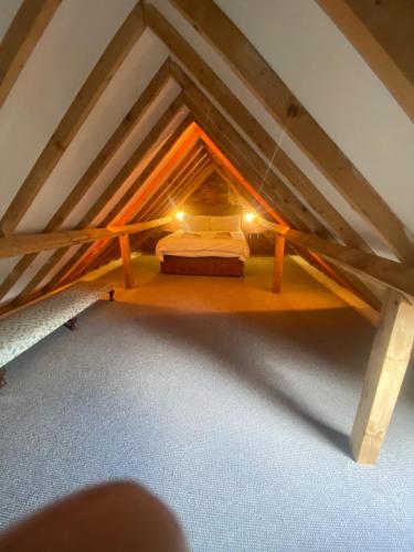 a room with a bed in a attic at Seafret Barn sleeps two, North Norfolk in Roughton