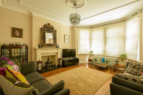 a living room with a couch and a fireplace at Luxury 6 Double Bedroom London Town house in Ealing