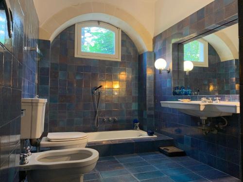 La salle de bains est pourvue de toilettes, d'une baignoire et d'un lavabo. dans l'établissement Palazzo Apostolico Orsini, à Lecce