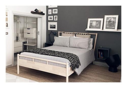 Schlafzimmer mit einem Bett mit einer schwarzen und weißen Bettdecke in der Unterkunft Taking a WALK in the beating HEART of NAVIGLI in Mailand