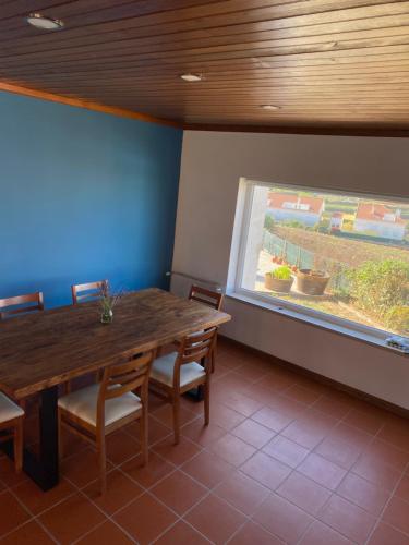 une salle à manger avec une table en bois et une fenêtre dans l'établissement Sunny Villa Minutes from the Beach, à Lourinhã