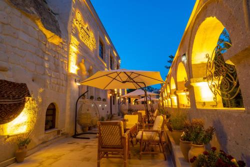a patio with a table and an umbrella at CAPPANAR CAVE HOTEL in Nar