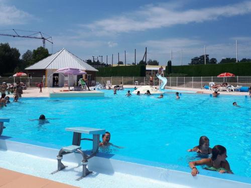 um grupo de pessoas a nadar numa piscina em Gîte Le Crozet, 5 pièces, 12 personnes - FR-1-496-100 em Le Crozet