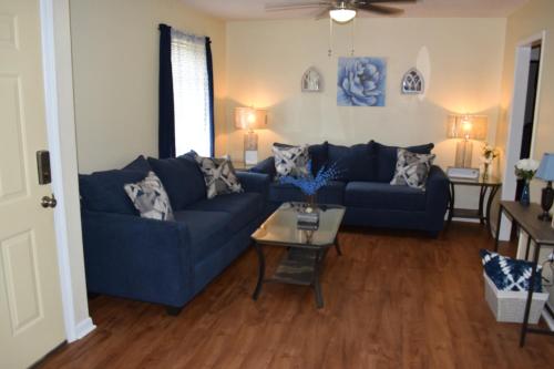a living room with a blue couch and a table at Comforts of Home in Gautier