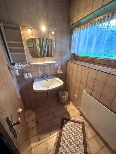 a small bathroom with a sink and a mirror at Haus Claudia in Schwendau