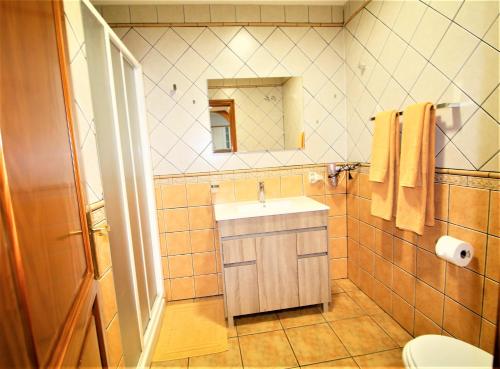 プエルト・デ・モガンにあるLas Cascadas Moganのバスルーム(洗面台、トイレ、鏡付)