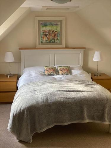 a bedroom with a large bed with two lamps at 47 High Street in Alness
