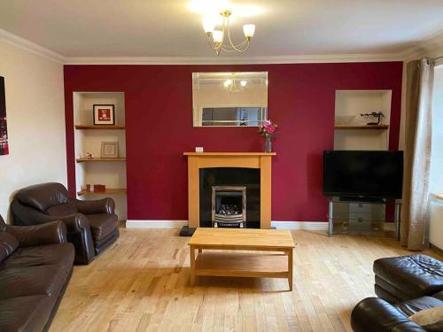 a living room with a couch and a fireplace at 47 High Street in Alness