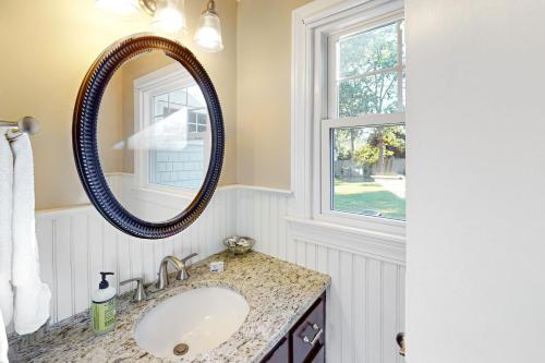 a bathroom with a sink and a mirror at Cape Escape in West Yarmouth