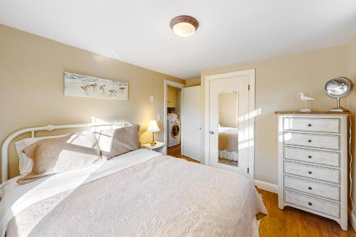 a bedroom with a white bed and a white dresser at Cape Escape in West Yarmouth