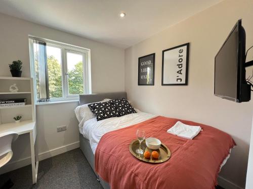 a bedroom with a bed with a tray of fruit on it at We House - Selly Oak Birmingham in Birmingham