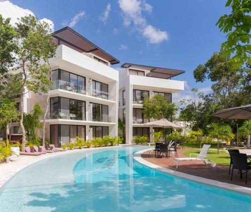a large building with a swimming pool in front of it at Casita Oleaje Luxury Cultural Sanctuary Spa in Tulum