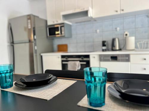 a kitchen with two plates and two glasses on a table at Red Apartment wt Indoor Parking near Marousi Hospitals, by PromosHomes in Athens
