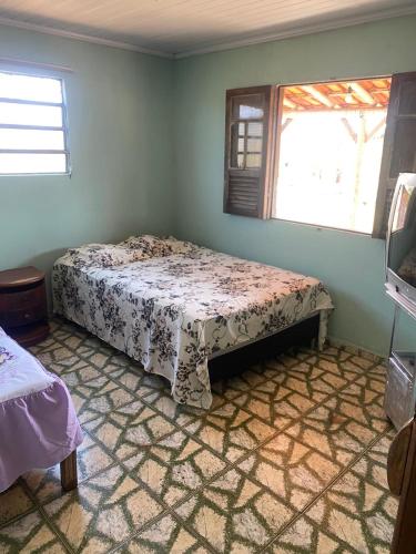 een slaapkamer met een bed in een kamer met een raam bij Casa Linha Férrea in Diamantina