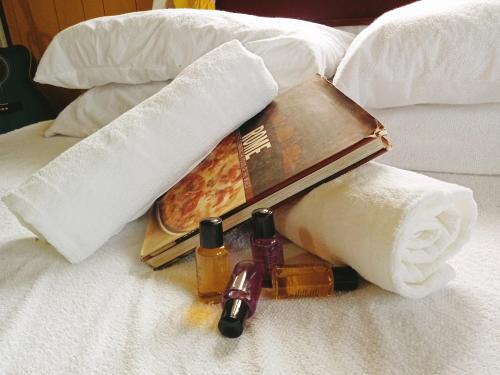 una scatola di pizza e asciugamani su un letto di Captain J's Boutique Crib a Kampong Pandan