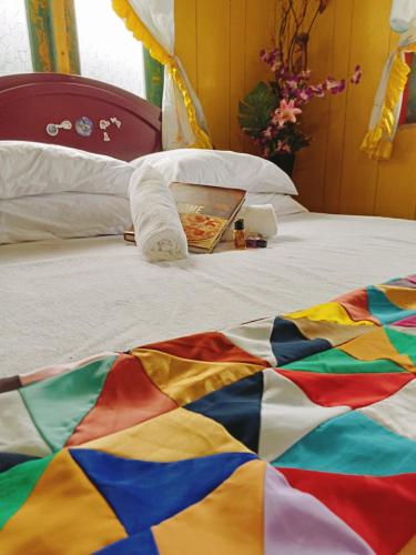 una coperta colorata su un letto con una pizza sopra di Captain J's Boutique Crib a Kampong Pandan