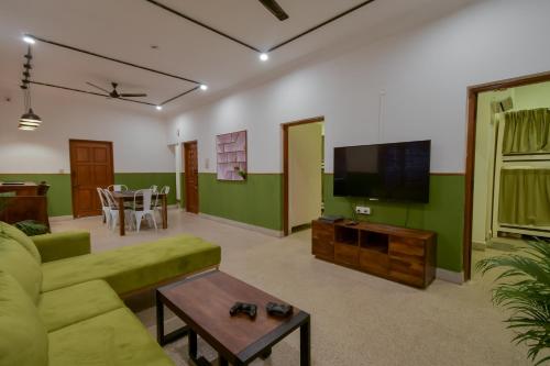 a living room with a couch and a tv at Snore Summore, Hostel in Koramangala in Bangalore