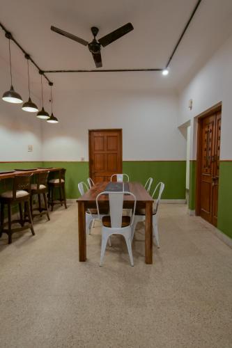 a dining room with wooden tables and white chairs at Snore Summore, Hostel in Koramangala in Bengaluru