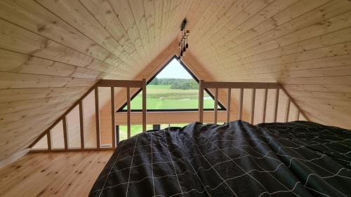 Bett in einem Zimmer mit einem großen Fenster in der Unterkunft Atpūtas namiņš Laureta 