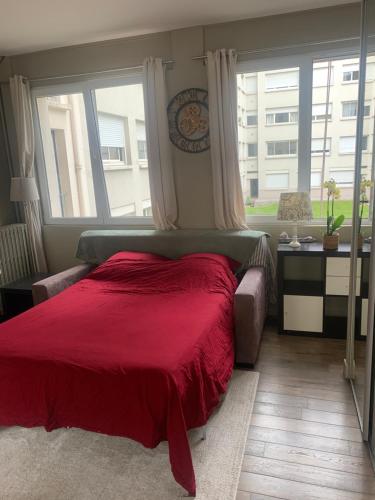 ein Schlafzimmer mit einem roten Bett und einem Fenster in der Unterkunft Porte Maillot-Charming and calm studio at Neuilly in Neuilly-sur-Seine