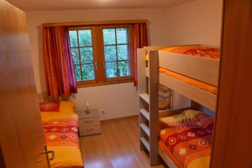 1 Schlafzimmer mit 2 Etagenbetten und einem Fenster in der Unterkunft Haus Brunnen (Anton Karlen) in Riederalp