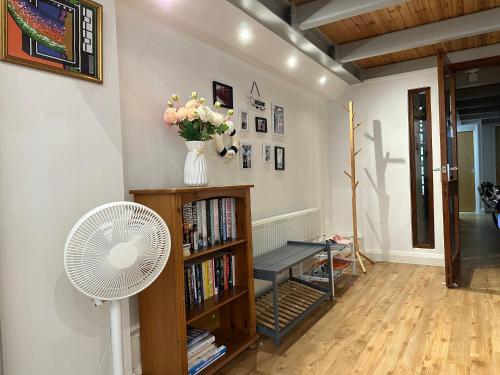 a living room with a fan and a book shelf at City Centre 3 bedrooms apartment with parking in Nottingham