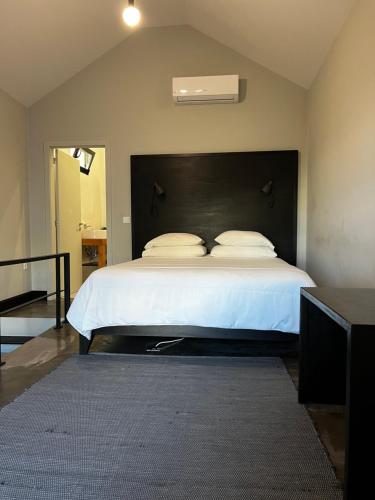 フンシャルにあるThe Loft Junctionのベッドルーム1室(大型ベッド1台、黒いヘッドボード付)