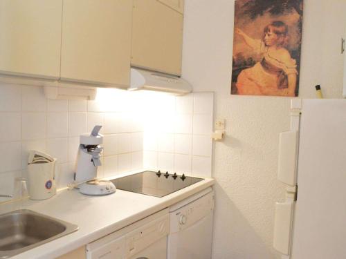 une petite cuisine avec un évier et un réfrigérateur dans l'établissement Appartement Cosy Proche Mer: 2 Pièces, 4 Couchages, Narbonne Plage - FR-1-229B-19, à Narbonne-Plage