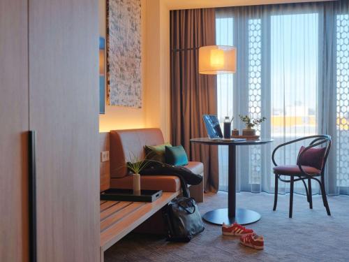 a hotel room with a couch and a table and chairs at Adina Apartment Hotel Munich in Munich