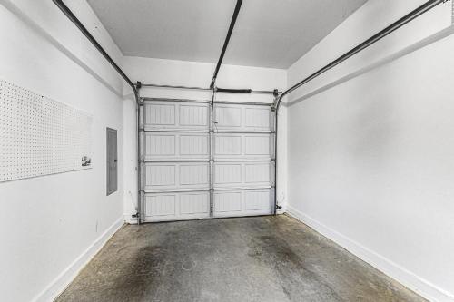 an empty room with white walls and a garage door at Brydcliffe Butte in Asheville