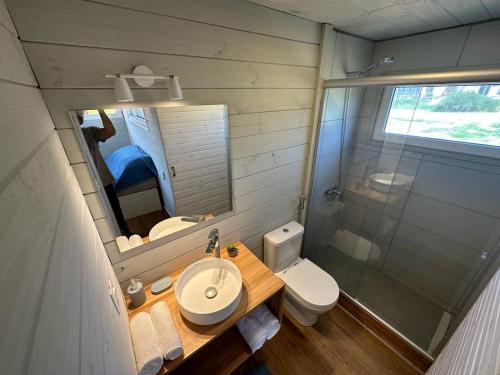 uma casa de banho com um lavatório, um WC e um espelho. em Amphibias em Punta Del Diablo