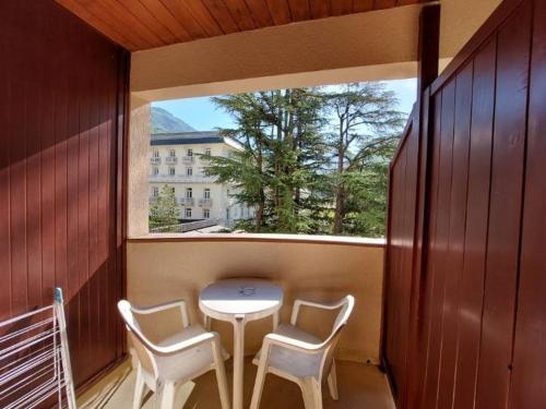 un balcon avec une table et deux chaises et une fenêtre dans l'établissement Studio accueillant avec balcon et WiFi à Brides-les-Bains - FR-1-512-191, à Brides-les-Bains