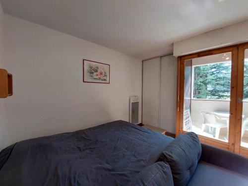 une chambre avec un lit et une grande fenêtre dans l'établissement Studio accueillant avec balcon et WiFi à Brides-les-Bains - FR-1-512-191, à Brides-les-Bains