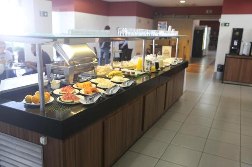 a buffet line with plates of food in a restaurant at Stop Inn Antonio Carlos in Belo Horizonte
