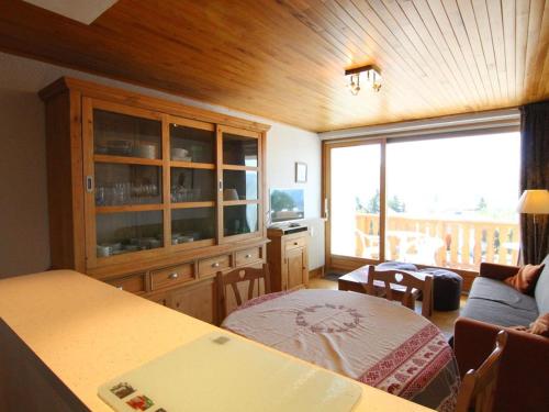a living room with a bed and a large window at Studio cosy pour 5 pers. à 50m des pistes - Alpe d'Huez - FR-1-405-200 in LʼHuez
