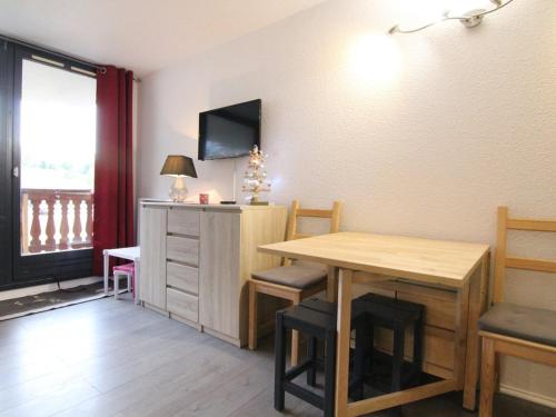 une salle à manger avec une table et une télévision dans l'établissement Charmant 2P, 5 pers, au pied des pistes, balcon est, animaux OK - L'Alpe d'Huez - FR-1-405-179, à L'Alpe-d'Huez