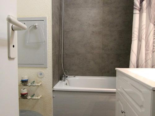 une salle de bain avec une baignoire blanche et une douche dans l'établissement Charmant 2P, 5 pers, au pied des pistes, balcon est, animaux OK - L'Alpe d'Huez - FR-1-405-179, à L'Alpe-d'Huez