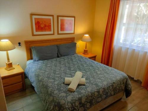 ein Schlafzimmer mit einem Bett mit Kreuz darauf in der Unterkunft Brookes Hill 1 Bedroom in Summerstrand