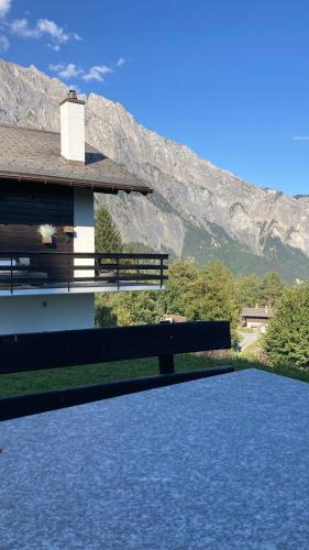 a bench sitting in front of a building with a mountain at Le Lézard et la Grenouille BnB in Ovronnaz