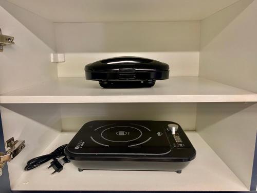 a black appliance is sitting on a shelf at MV 77A Incrível Apartamento Em Frente Ao Metrô Brás ! - Rua Coronel Mursa, 56 - Bras in Sao Paulo