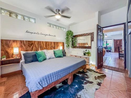 a bedroom with a large bed with blue and green pillows at Casa Paloma - Zona Romantica in Puerto Vallarta