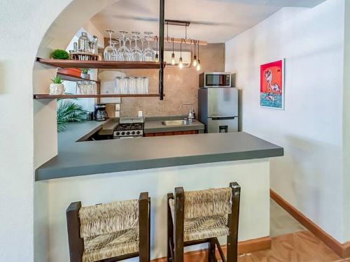 a kitchen with a counter and two chairs in a room at Casa Paloma - Zona Romantica in Puerto Vallarta