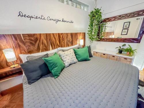 a large bed with green and blue pillows on it at Casa Paloma - Zona Romantica in Puerto Vallarta