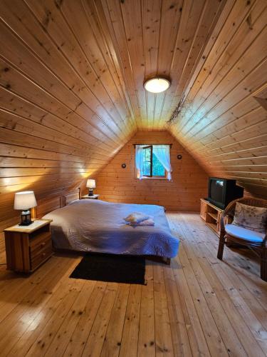 a large bedroom with a bed in a wooden ceiling at Domek Górski Promyk z kominkiem in Wisła