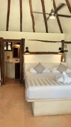 a bedroom with two white beds in a room at La Conchita Tulum in Tulum